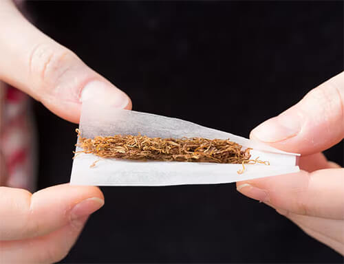 Mão enrolando cigarro