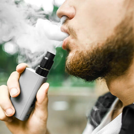 O que é vaper? pessoa soltando fumaça pela boca segurando um vaper